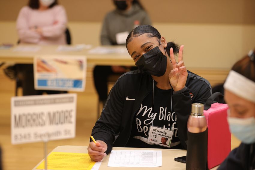 female student wearing mask holding peace sign at MLK event