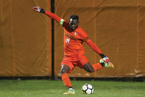 #24 on the Men’s Soccer team powerfully kicks the ball across the field