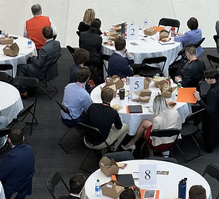 People seated at tables watching a speaker during the 2022 LEAPS conference