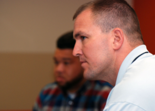 Ben Hartsock (foreground) and Jonathan Goodwin (background) listen to Coach Babers. 