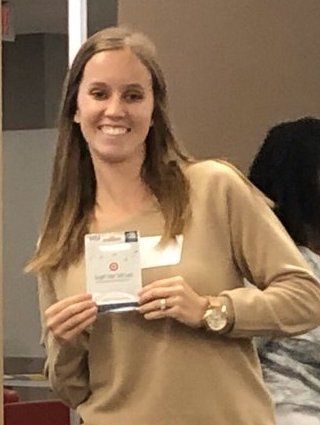 Lisa Carlson smiles for the camera holding her award