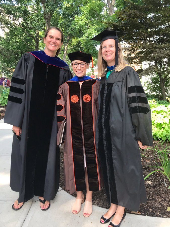 Distinguished Professor Wendy Manning, Dr. Kasey Eickmeyer, and Distinguished Professor Susan Brown at graduation ceremony in front of landscape