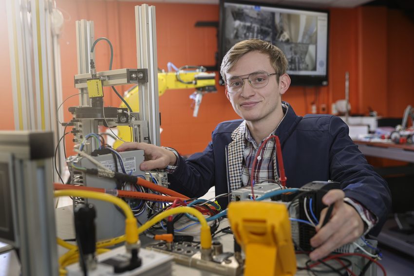 Student sitting amongst electronic equipment