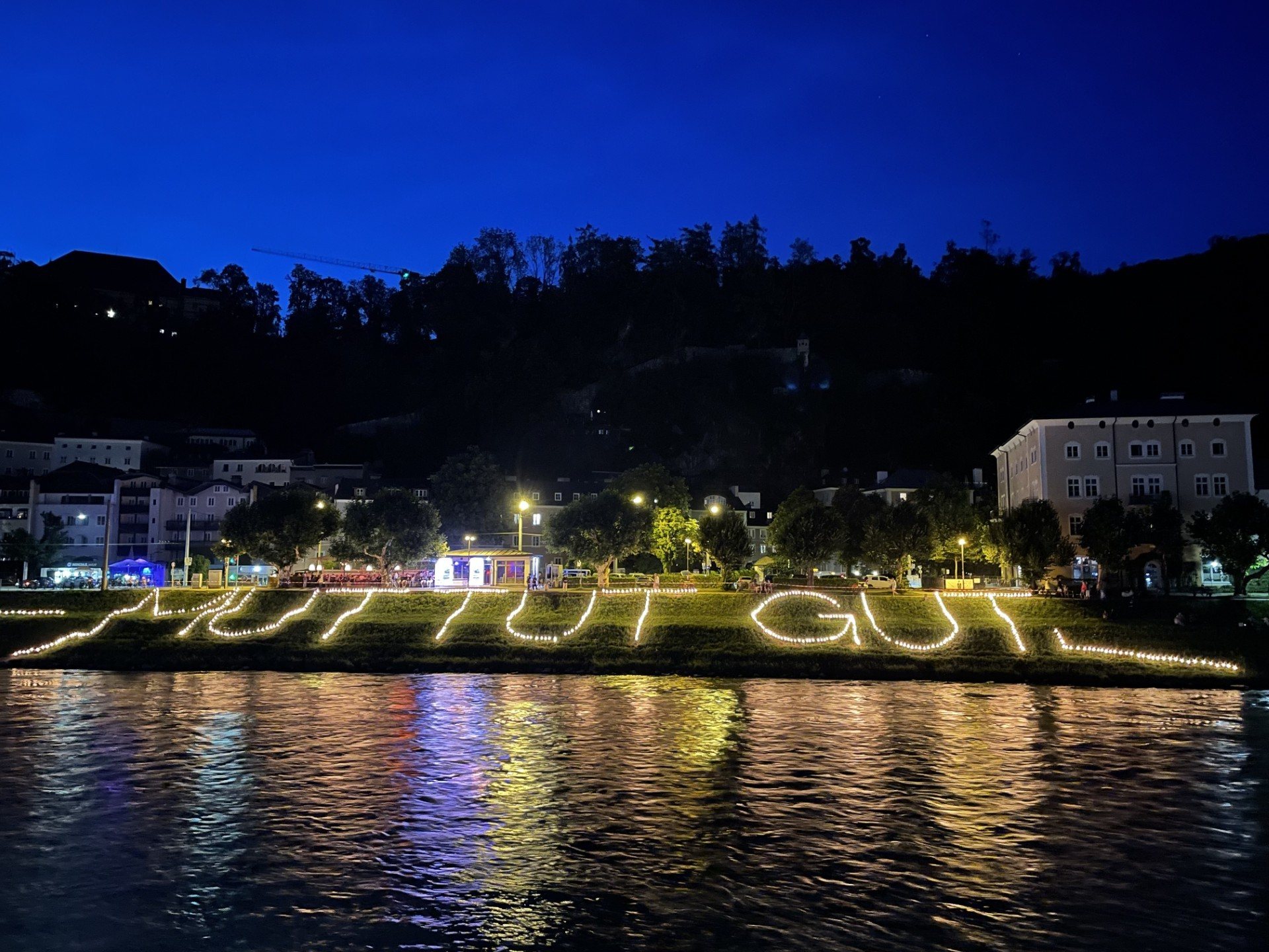 Mut tut gut is spelled out in lights by the shore