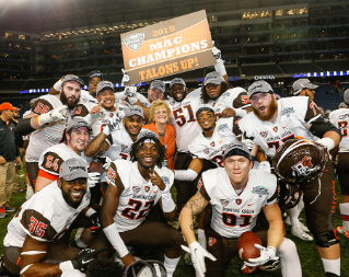 Members of the  BGSU Falcon football team celebrate the 2015 MAC Championship win with President Mary Ellen Mazey.