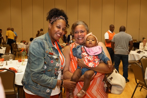 Two women hold a baby