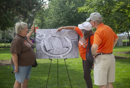 Three people look at a photograph