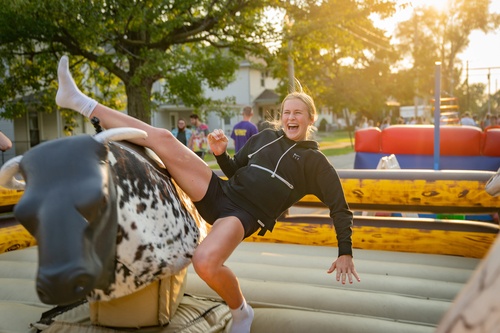 A woman falls off a mechanical bull