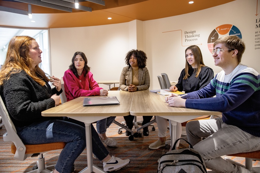 Students sit at a table with Life Design staff members