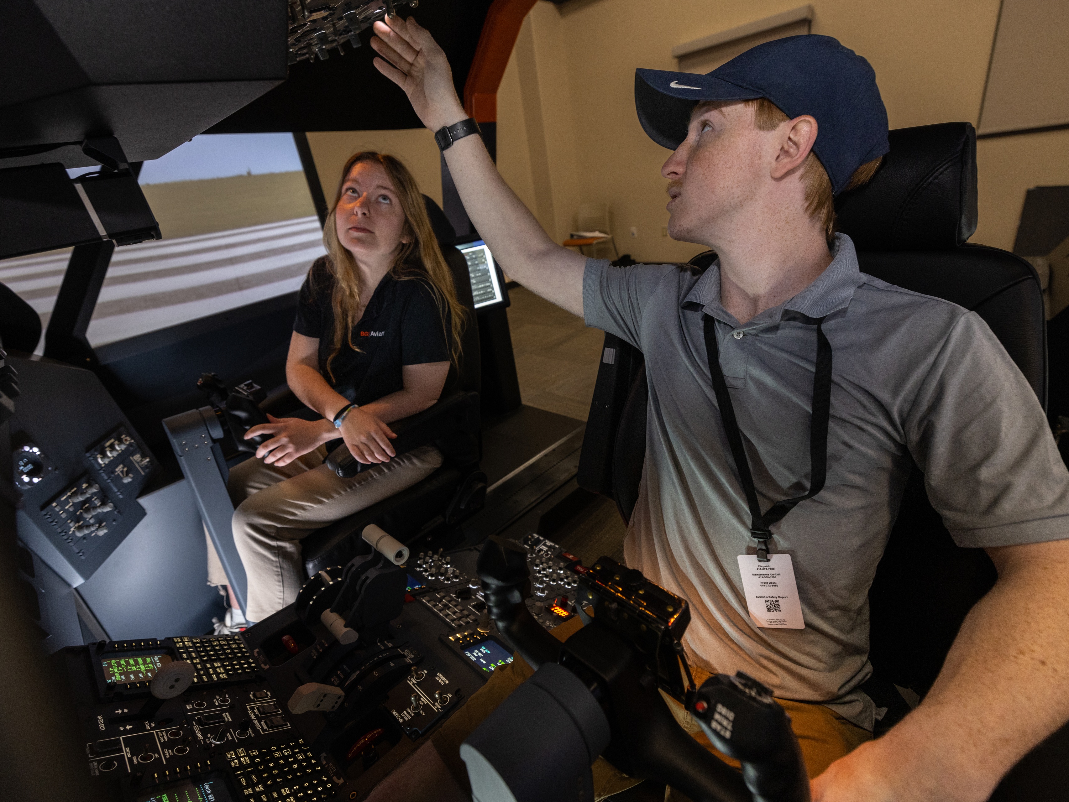 BGSU aviation students push buttons and flip switches in a flight simulator