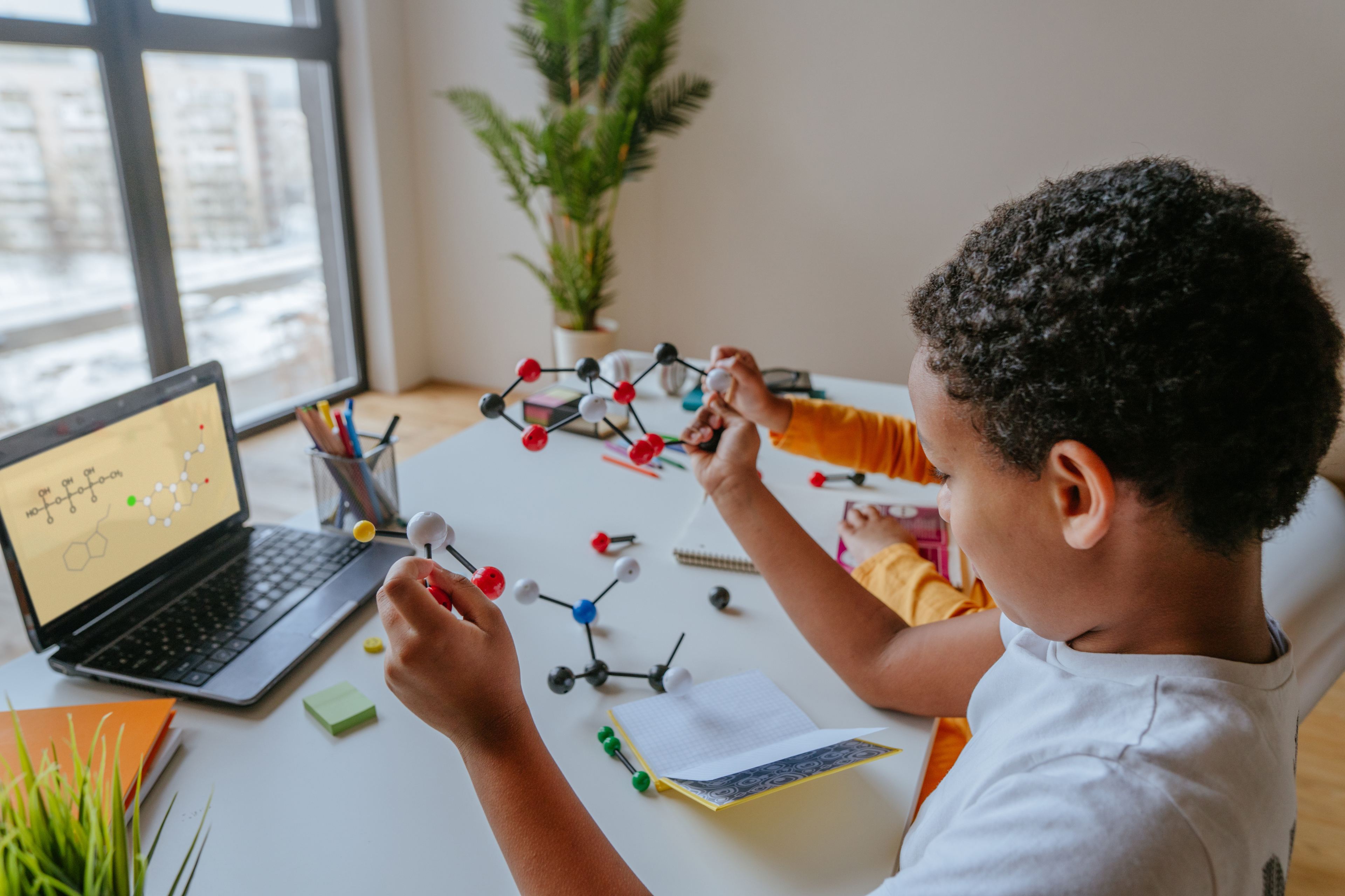  A boy holds molecular bonds while learning about chemistry from a computer