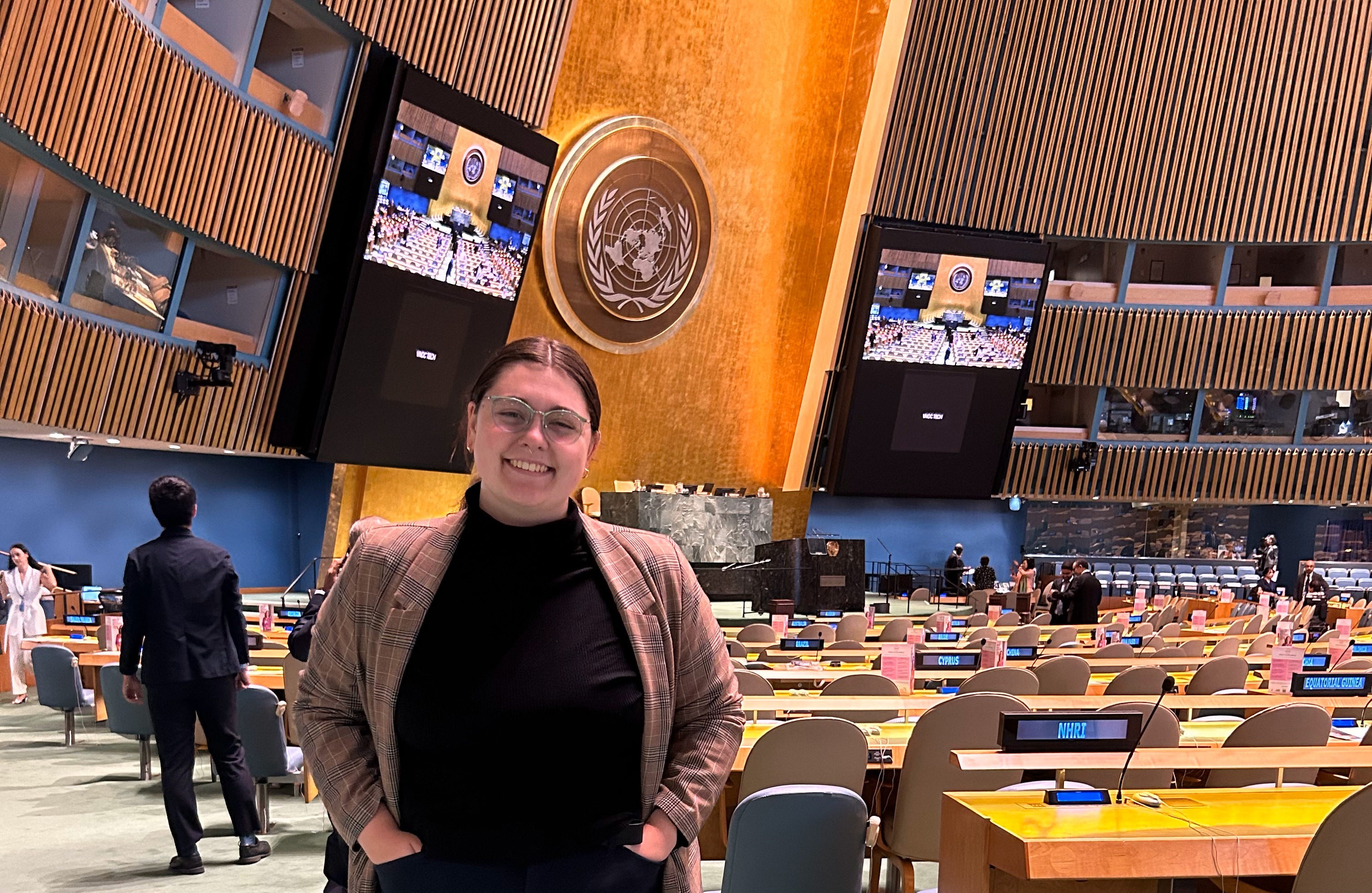A person stands inside a meeting room inside the United Nations.