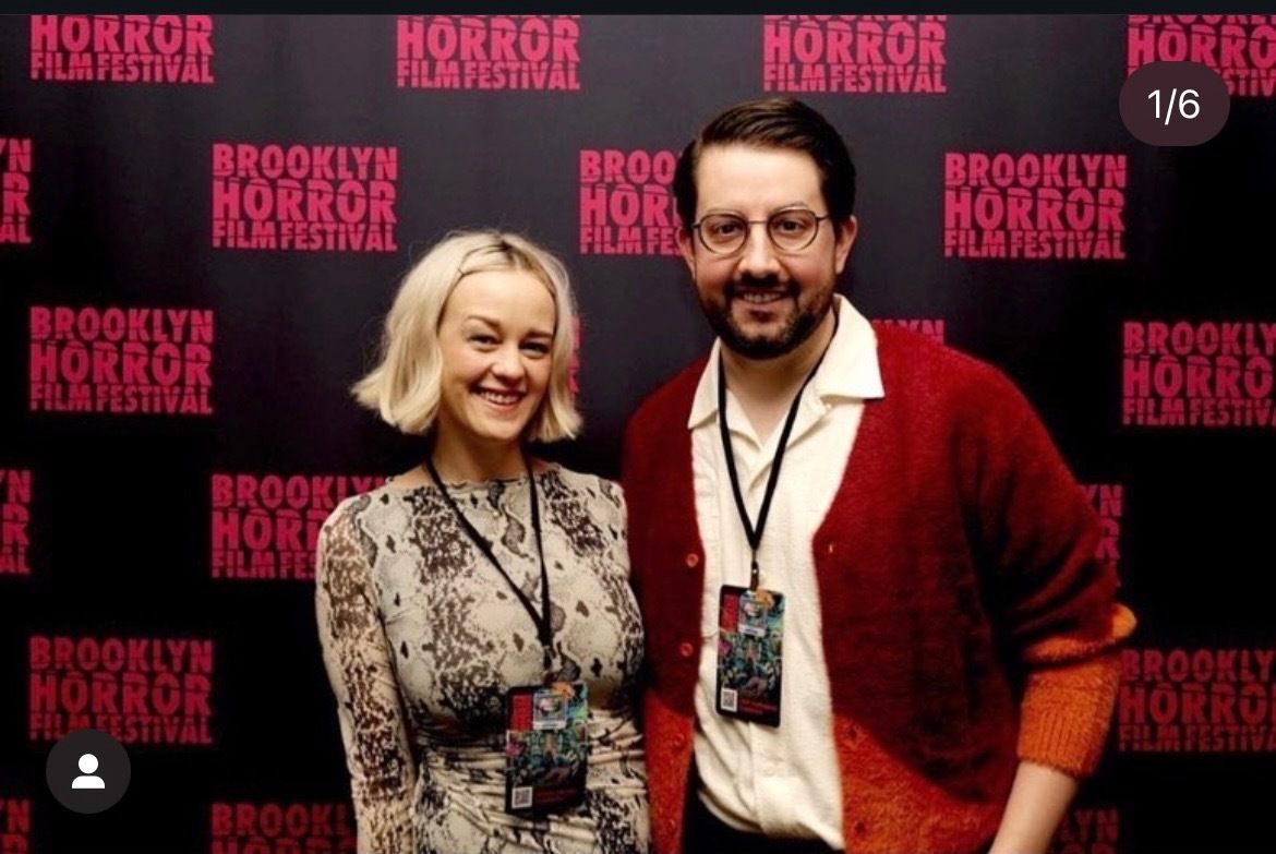 Two people stand in front of a banner that reads Brooklyn Horror Film Festival.