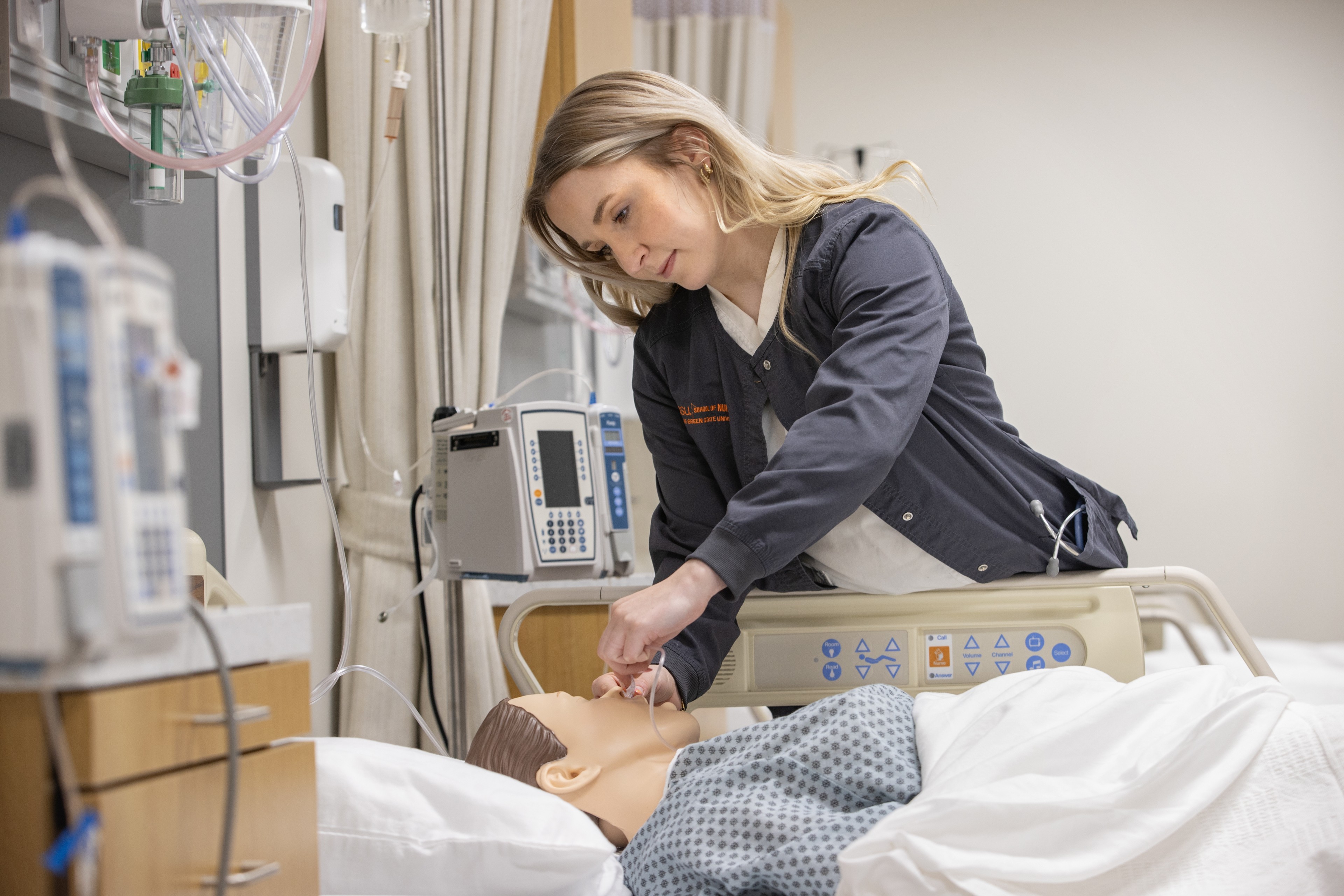 A student nurse practices a skill in the BGSU simulation lab in Central Hall.