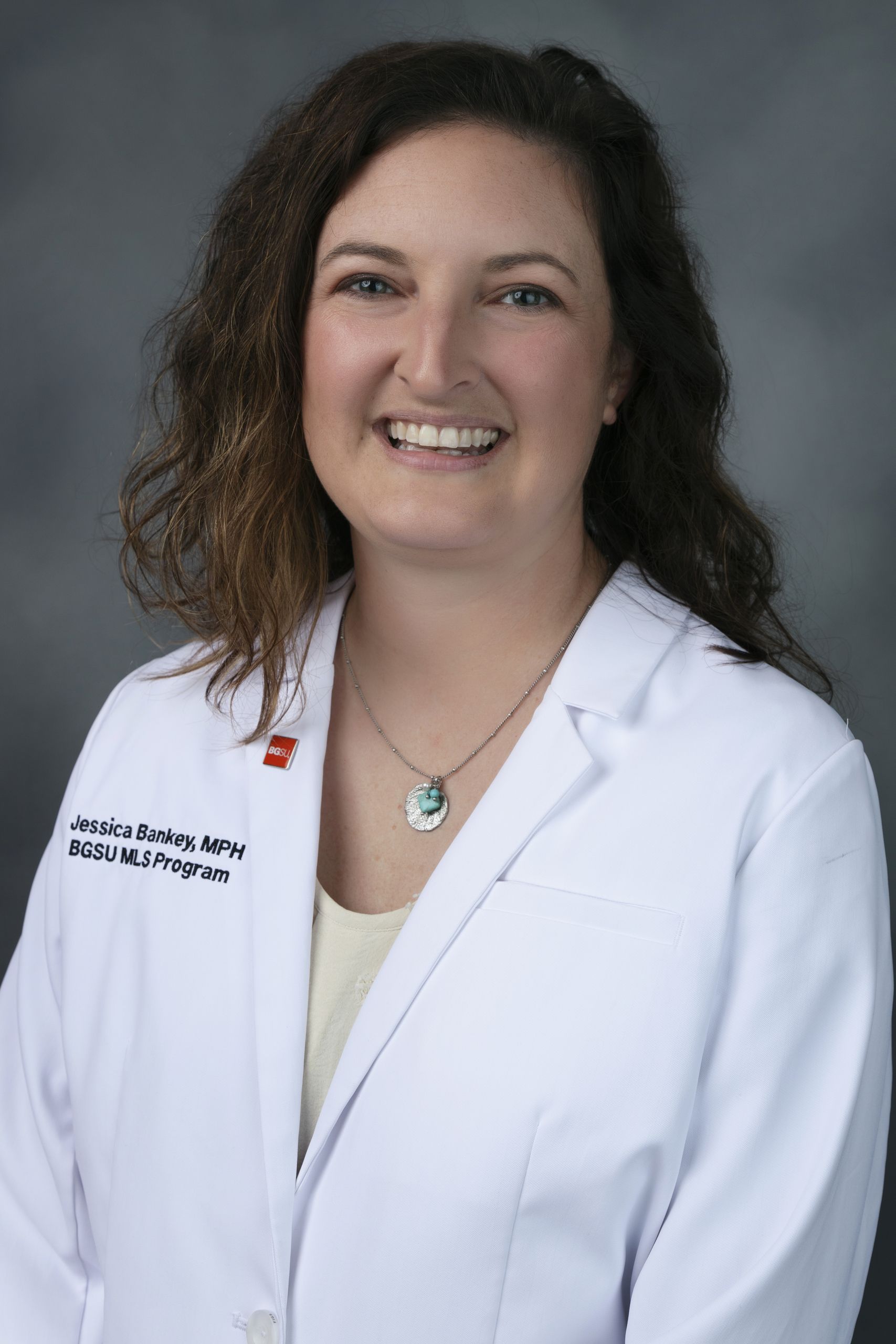 Woman poses for a picture wearing a white medical coat