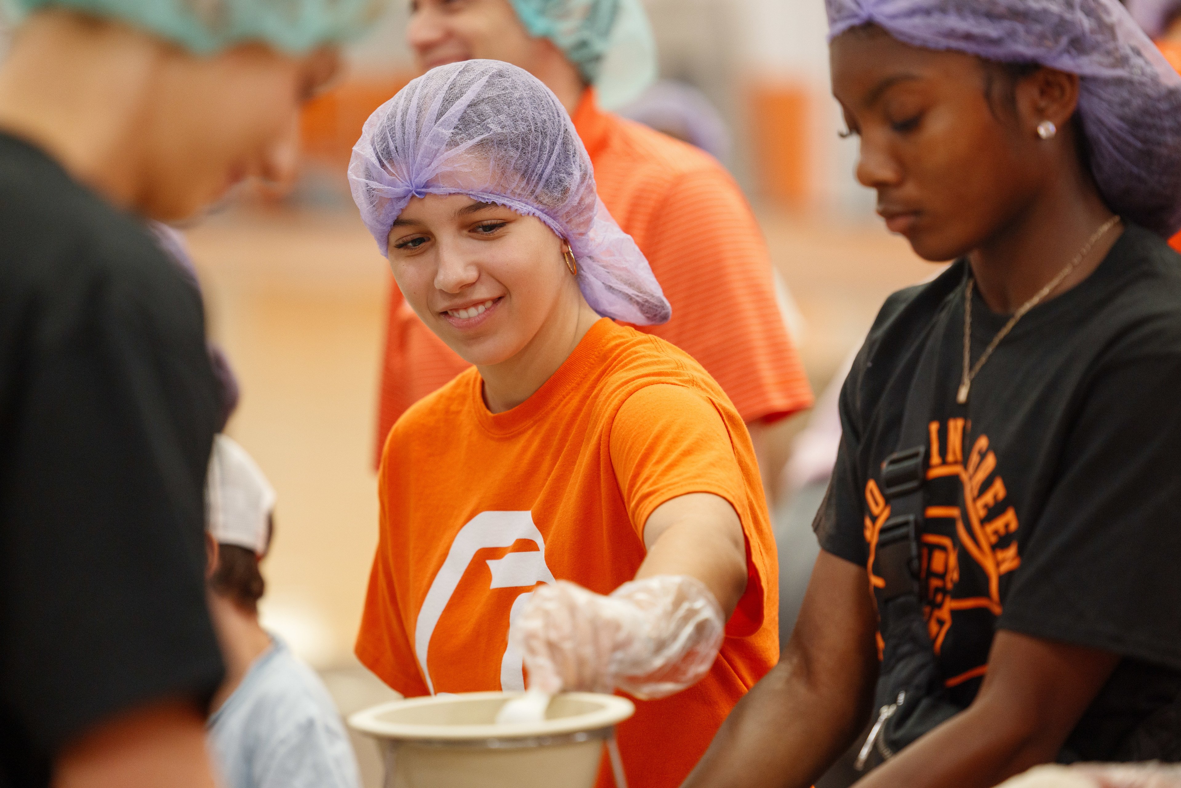 Girl wearing a hair net volunteers