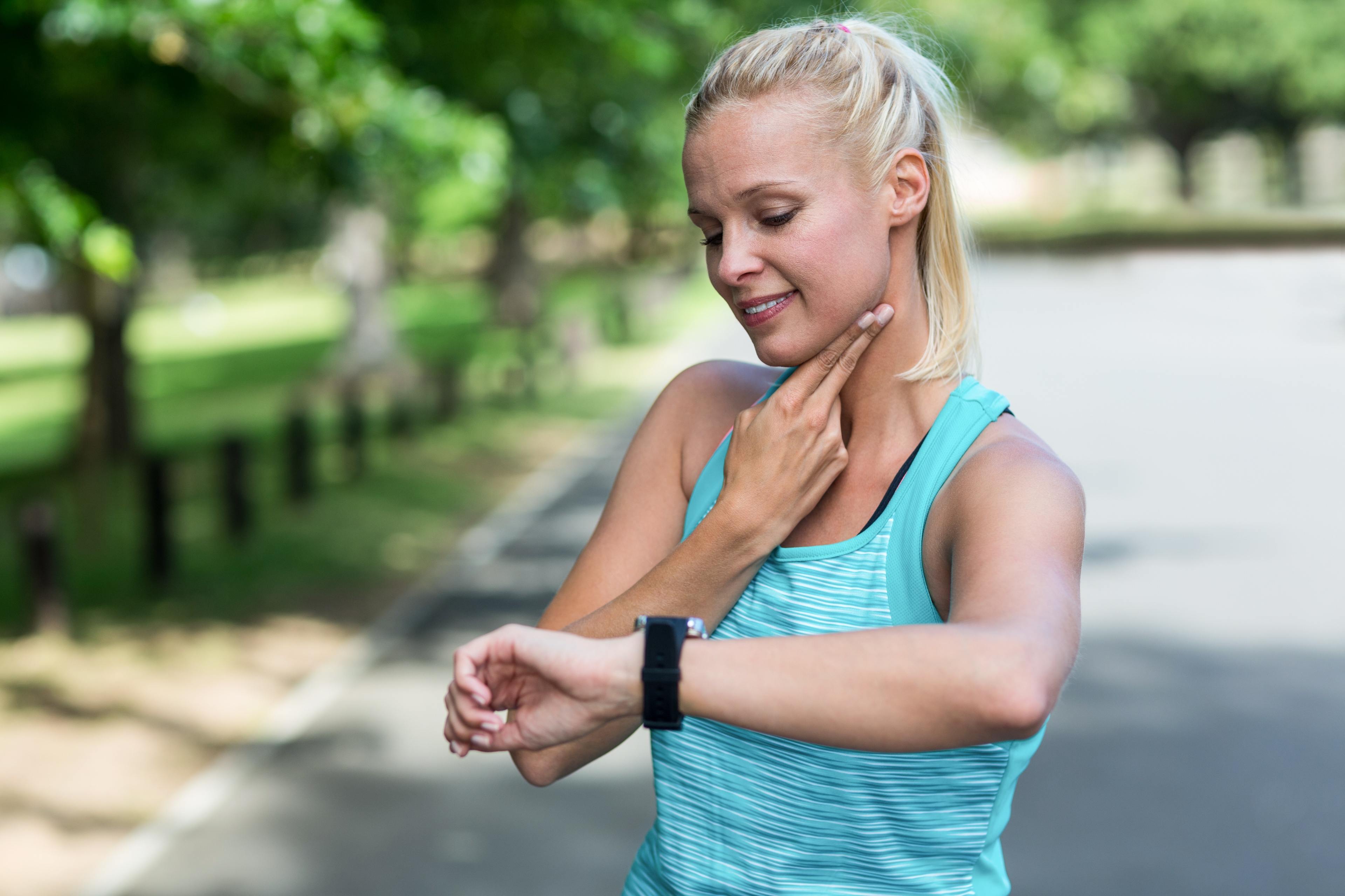 Woman checks her pulse while looking at her watch