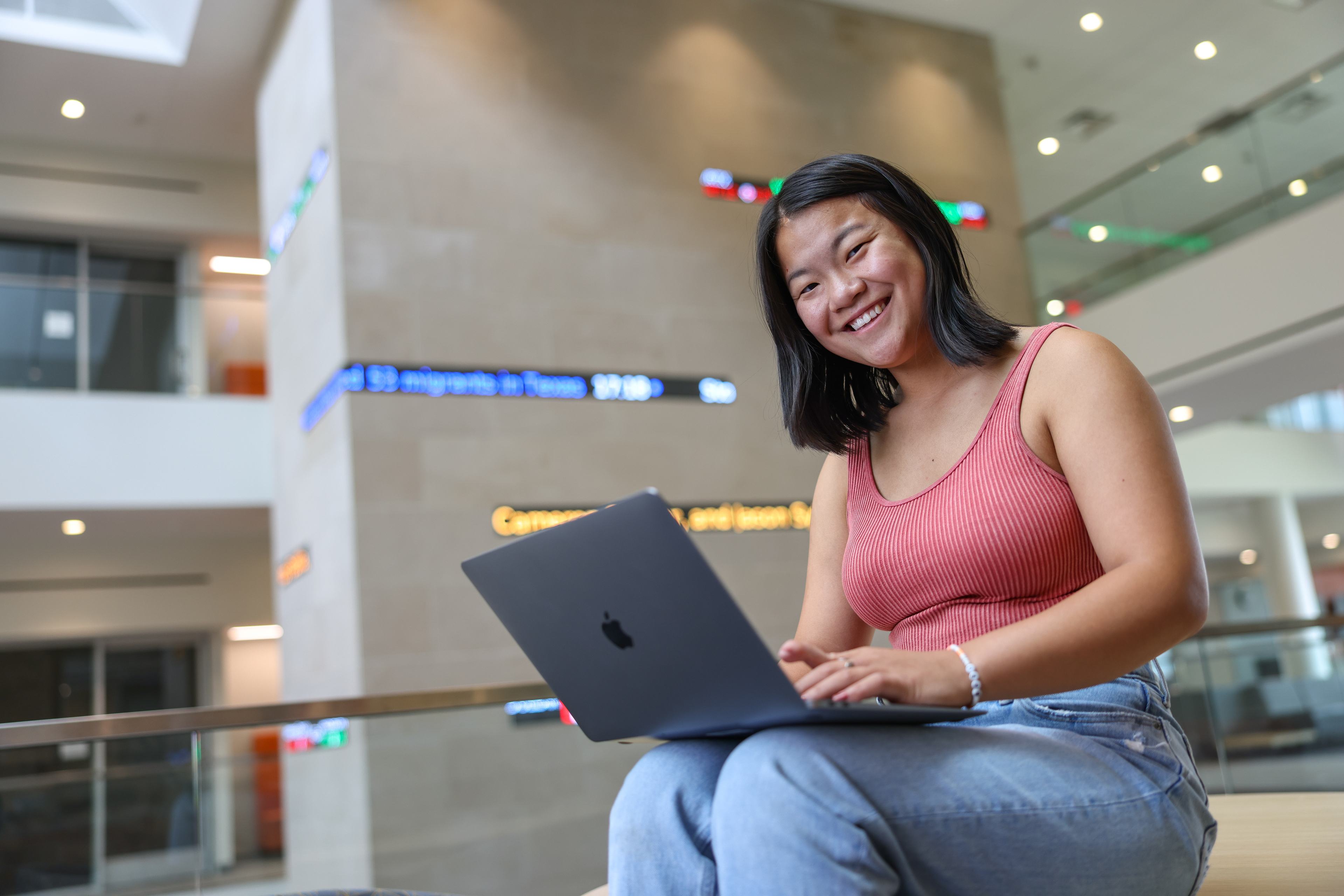 Girl works on a laptop inside the BGSU Schmidthorst College of Business