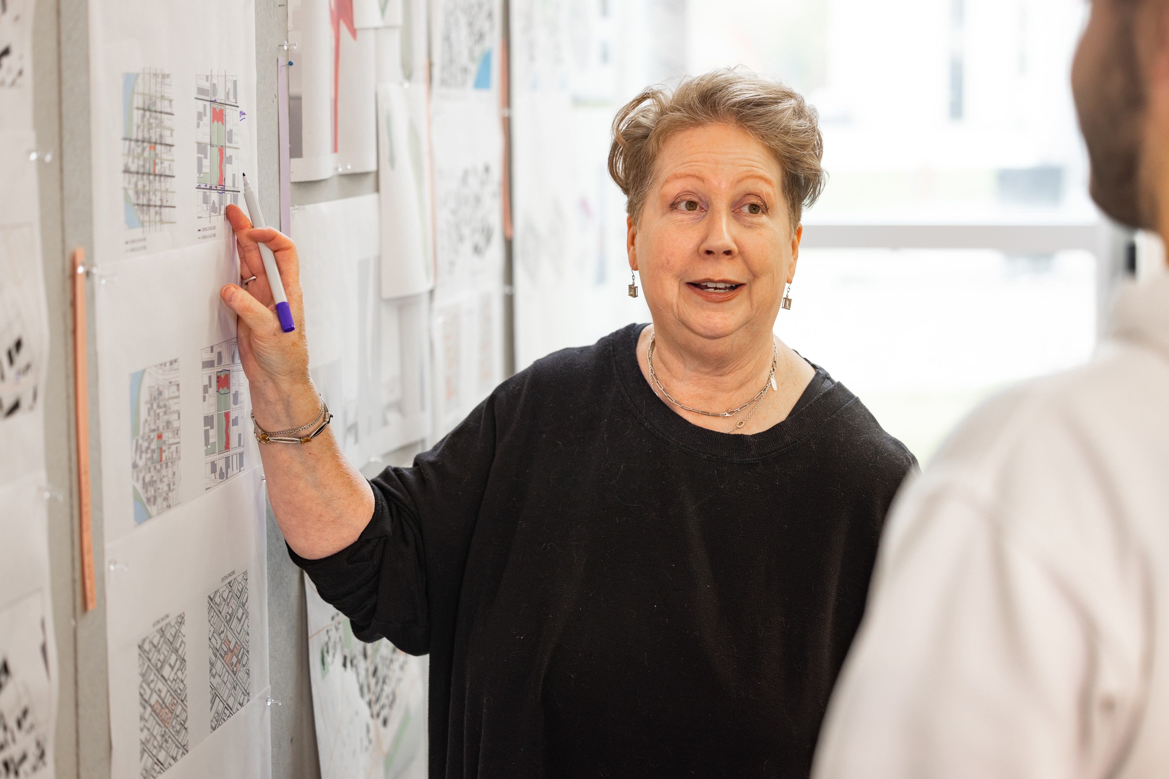 A professor stands at a whiteboard.