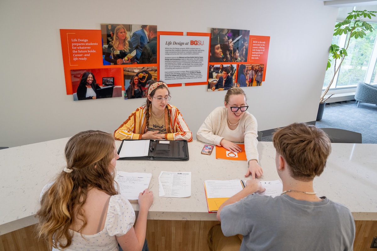 People sit at a table in the Michael and Sara Kuhlin Hub for Career Design and Connections. 