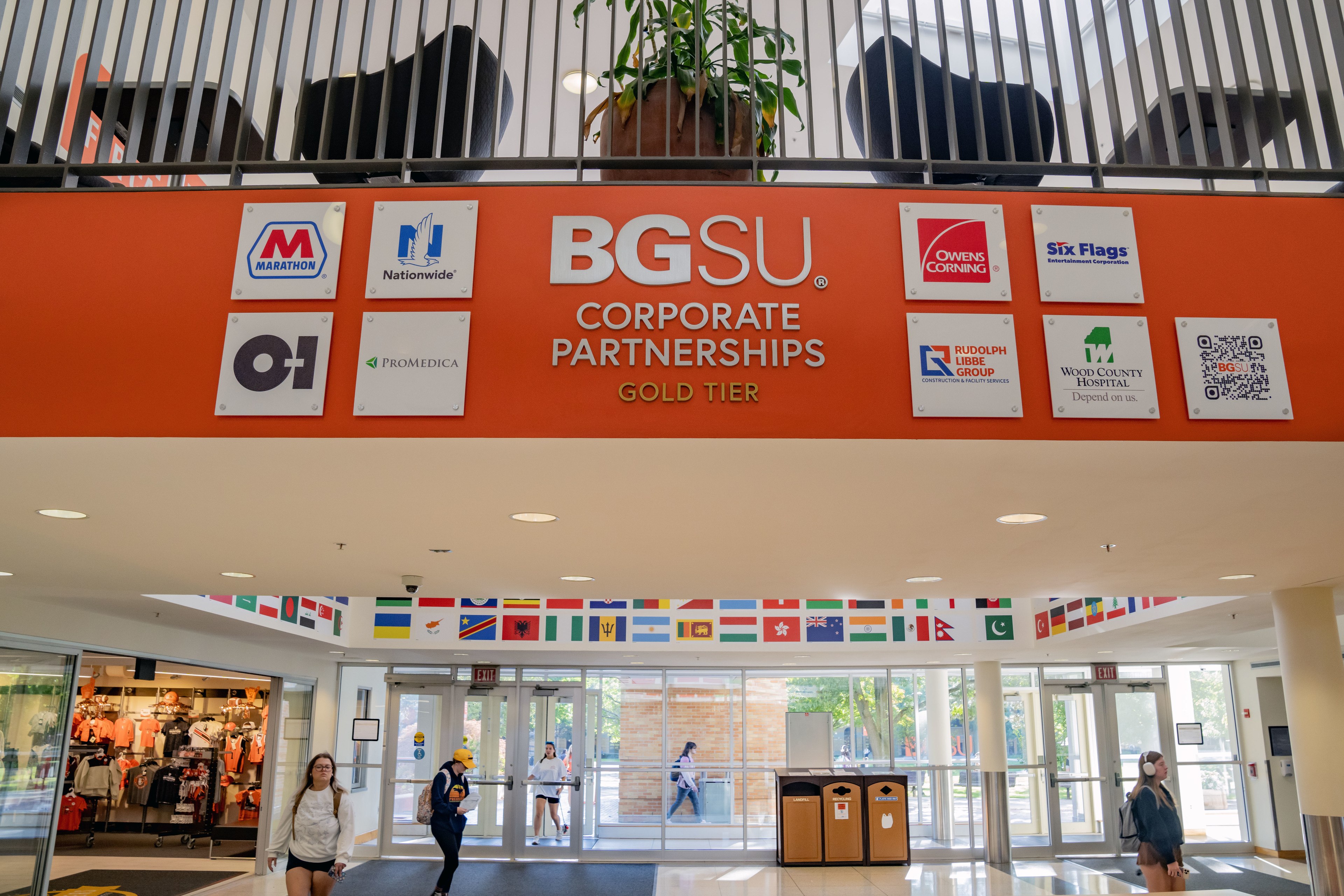 An orange wall in the BGSU Bowen-Thompson Student Union with company logos.