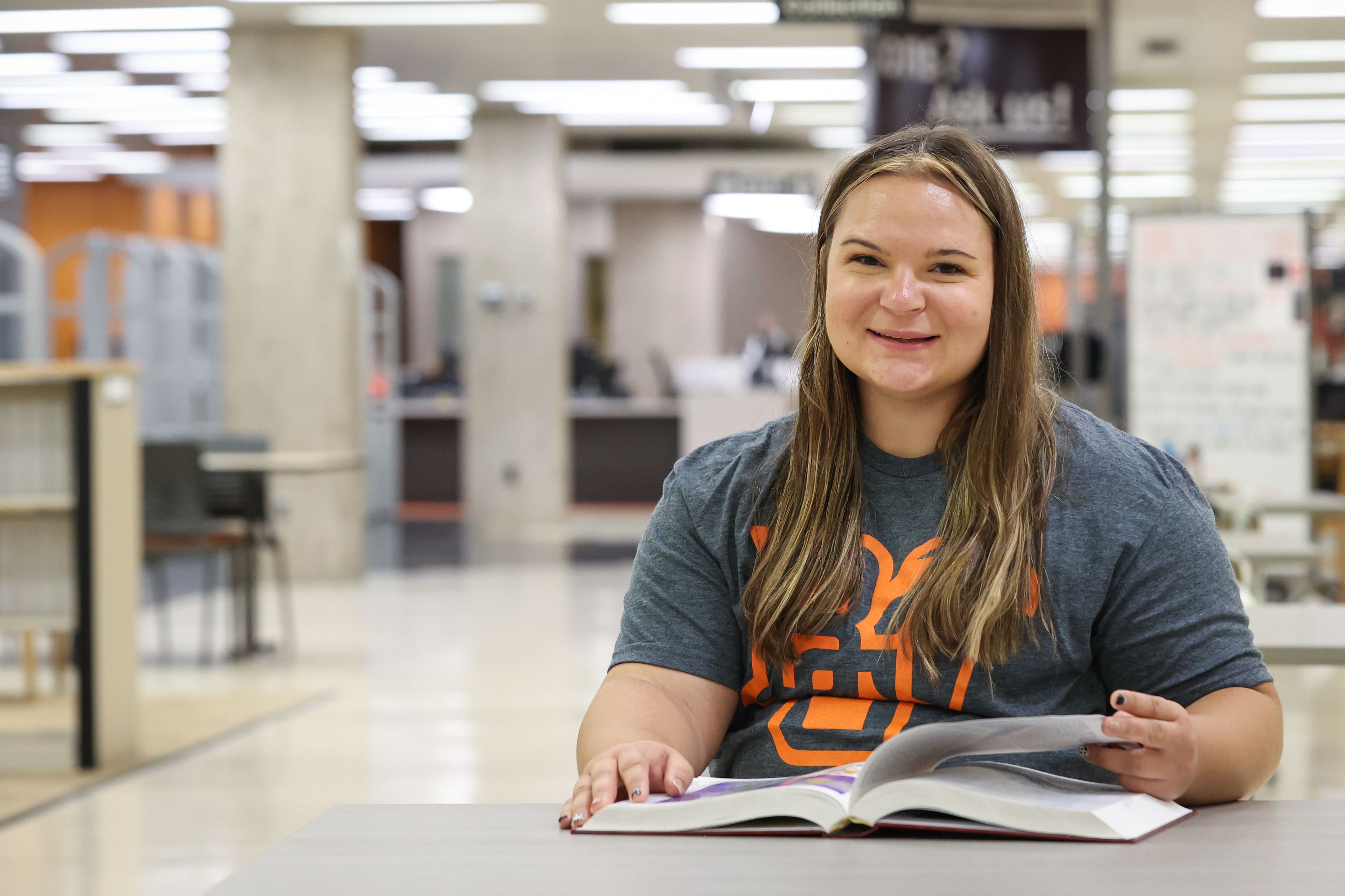 A BGSU student sits at a desk in the library.