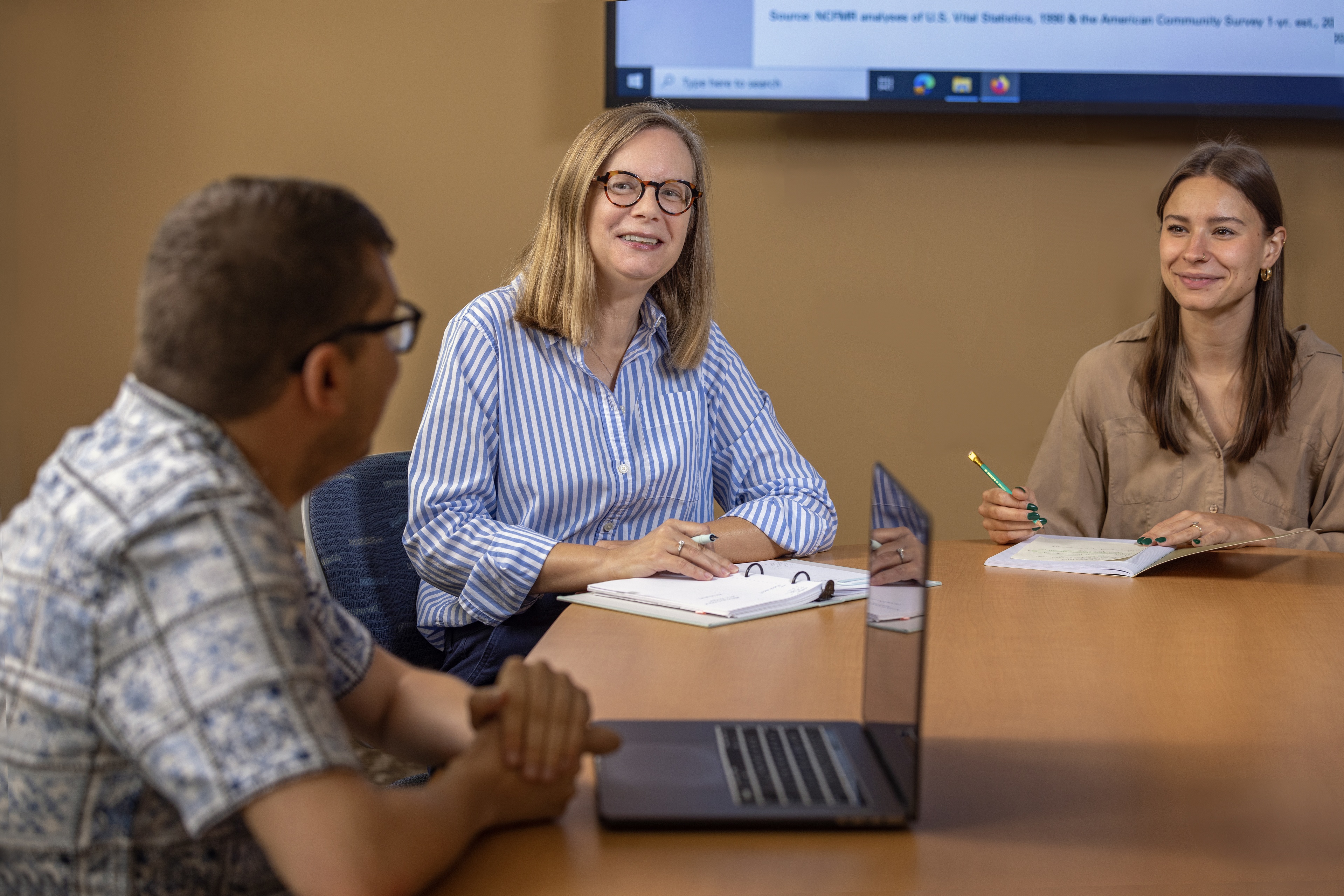 Dr. Susan L. Brown speaks with students at a table.