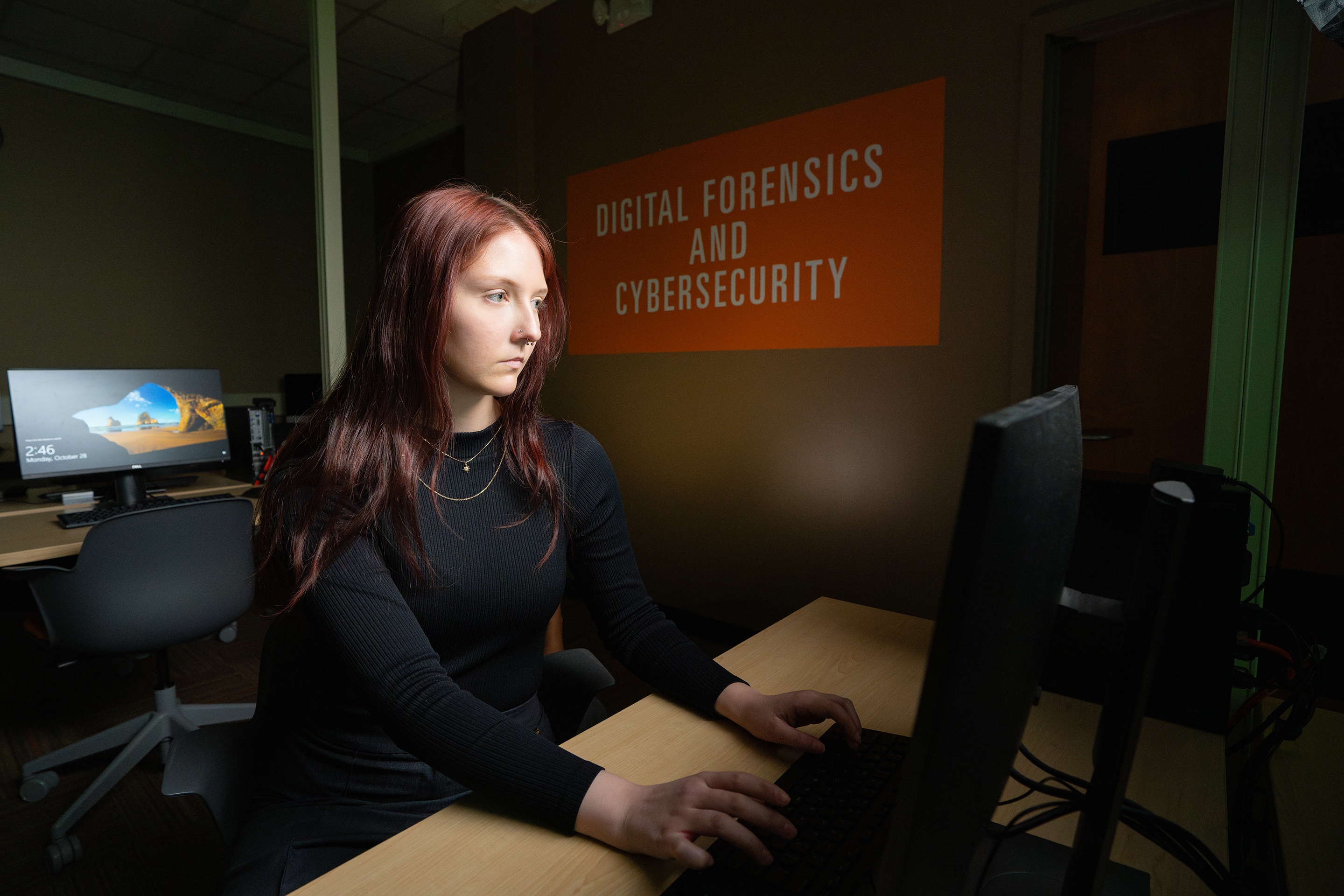 A woman poses for a picture in a computer lab