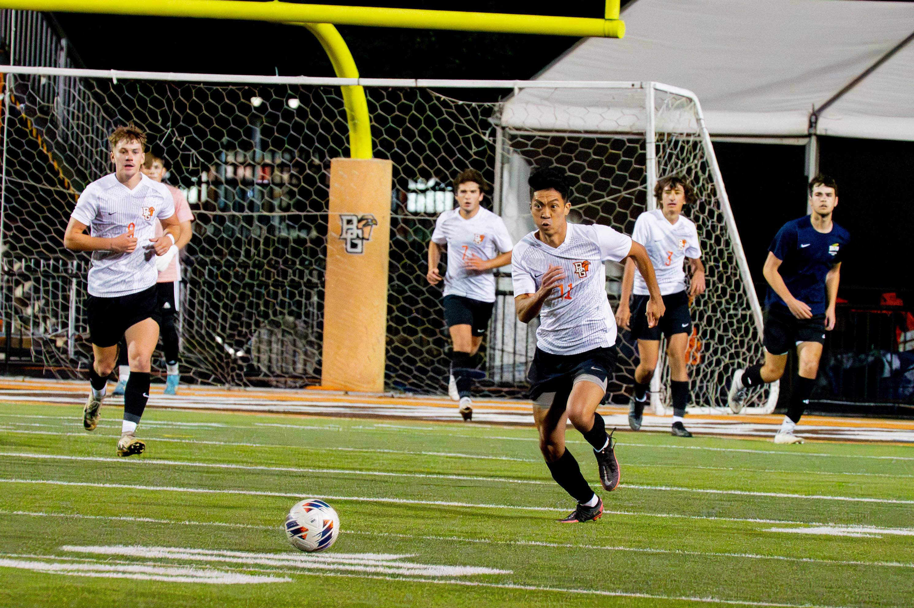 A soccer player chases down a ball