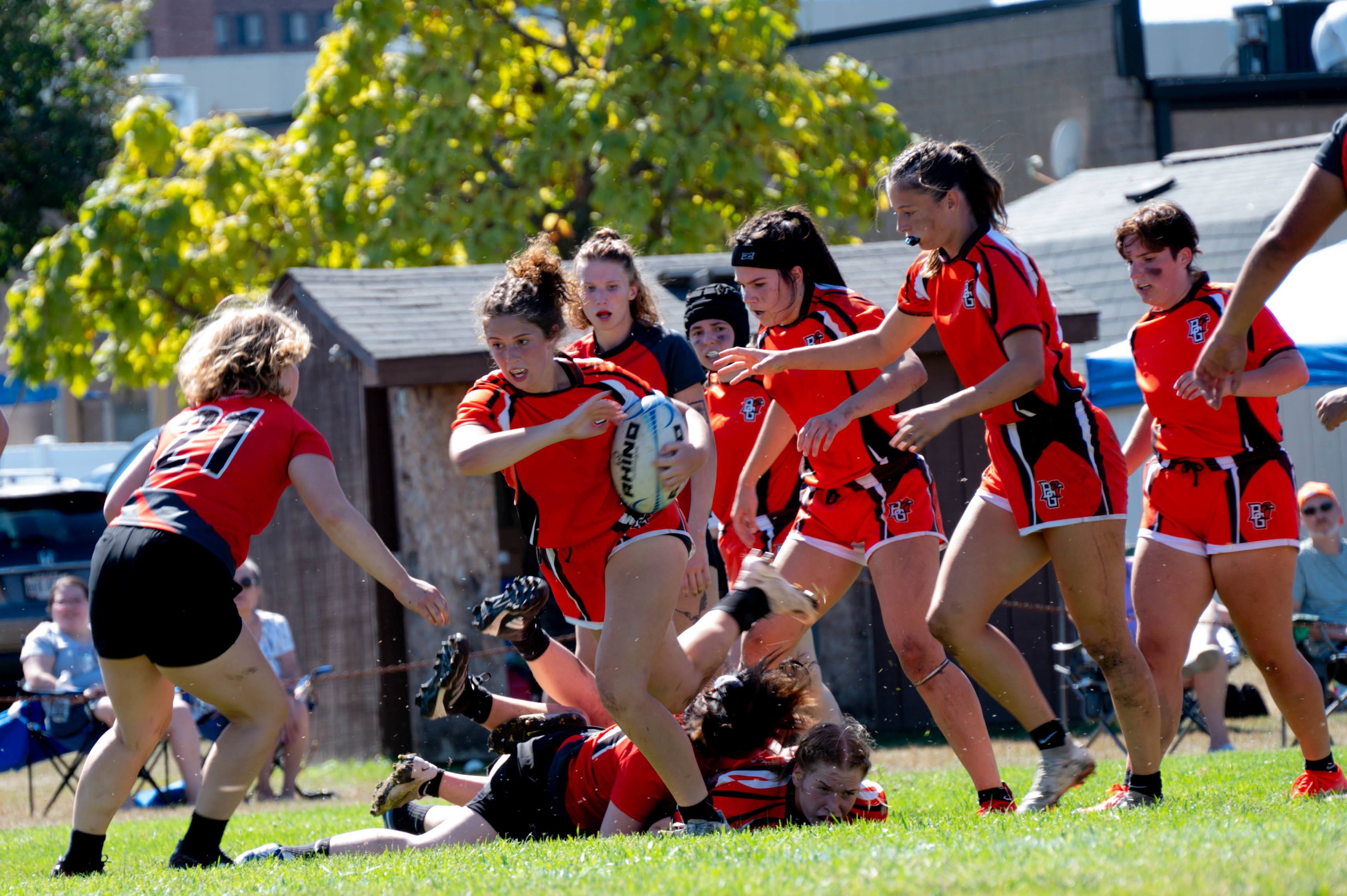 A rugby player runs with the ball.