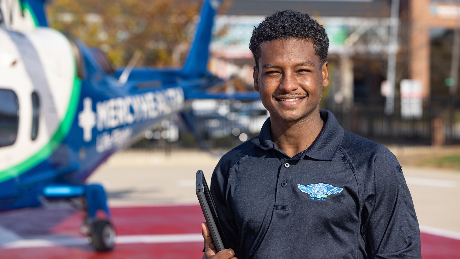 A person stands in front of a medical helicopter.