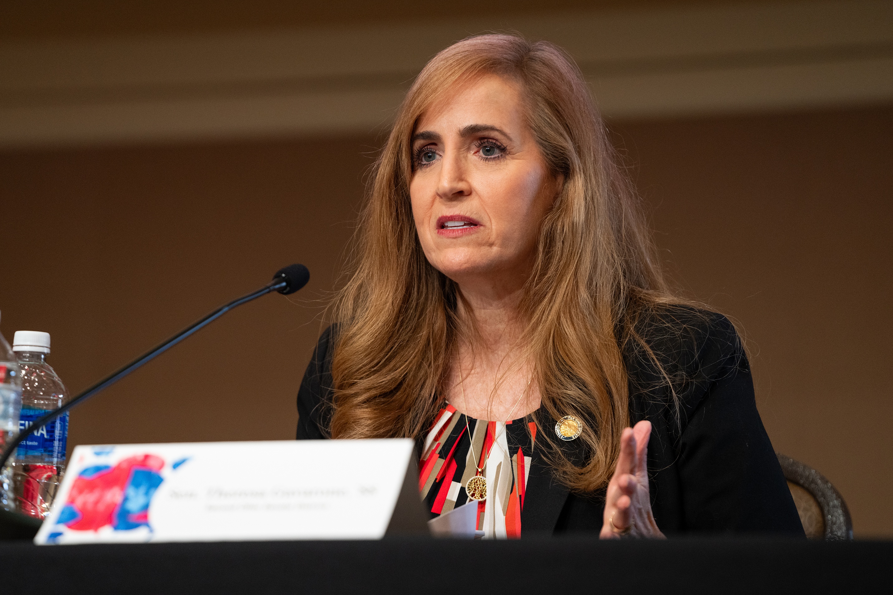 A person speaks into a microphone on a stage.