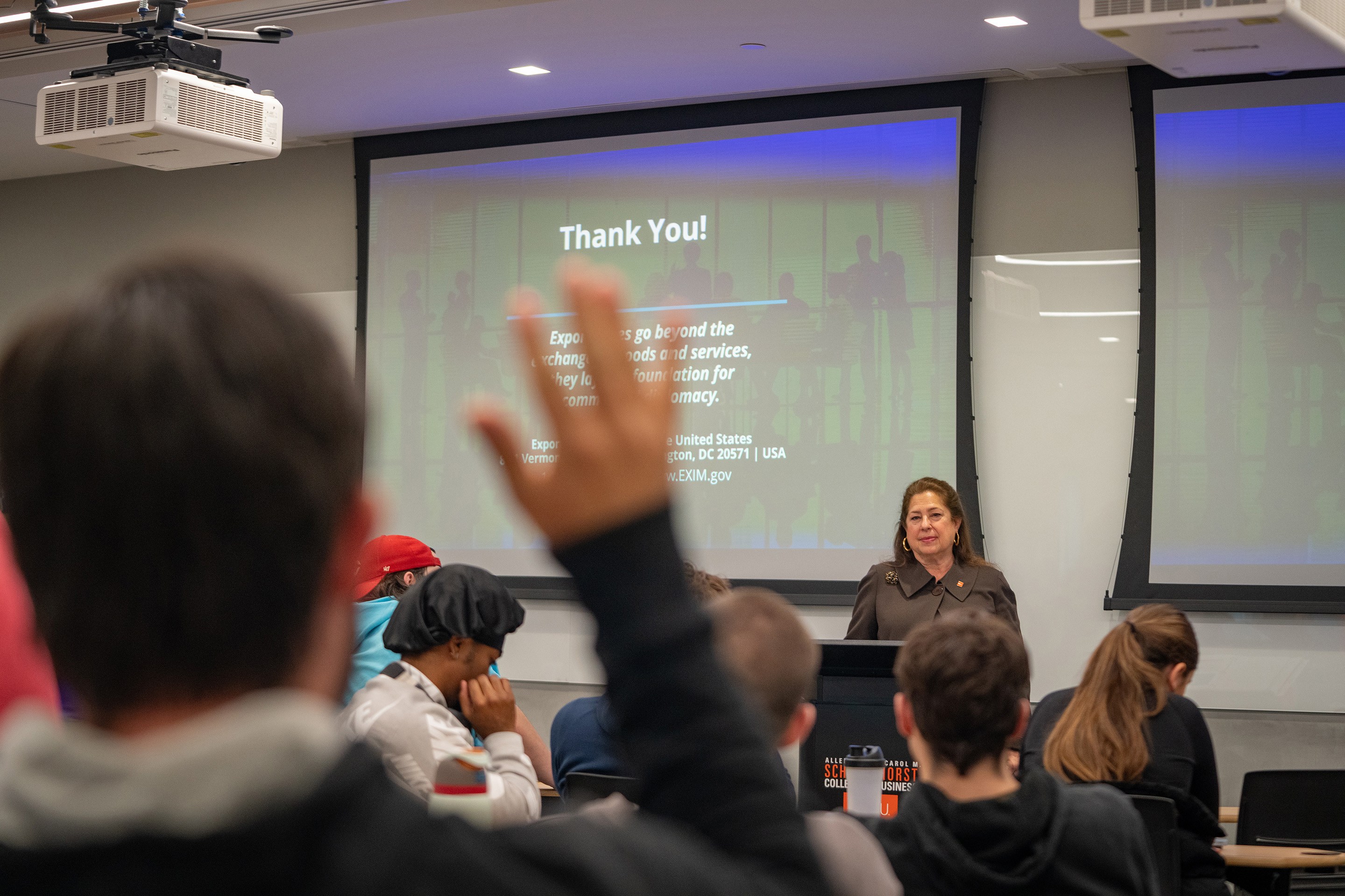 Someone raises their hand to ask a question.