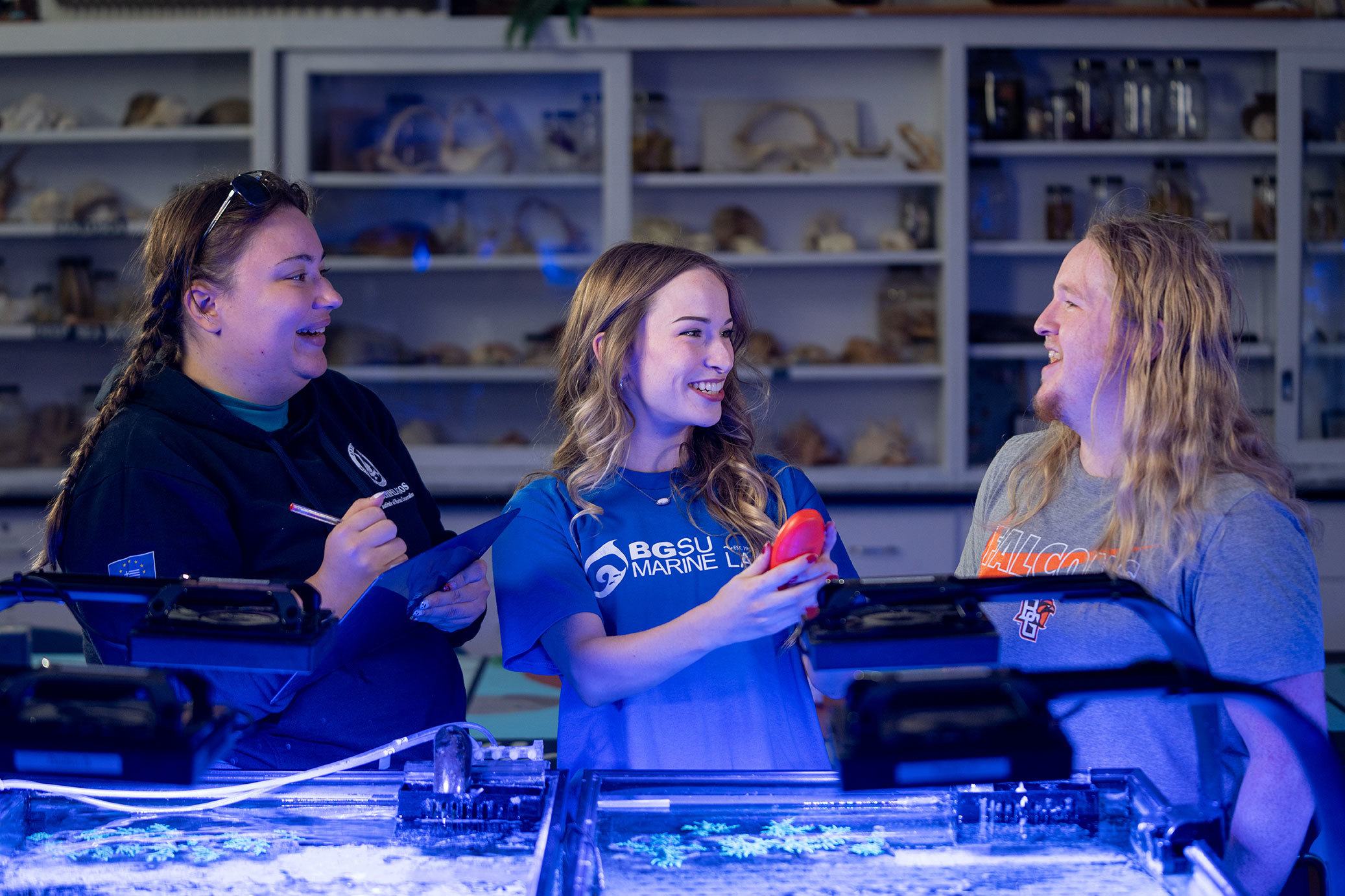 Three students work at a fish tank.