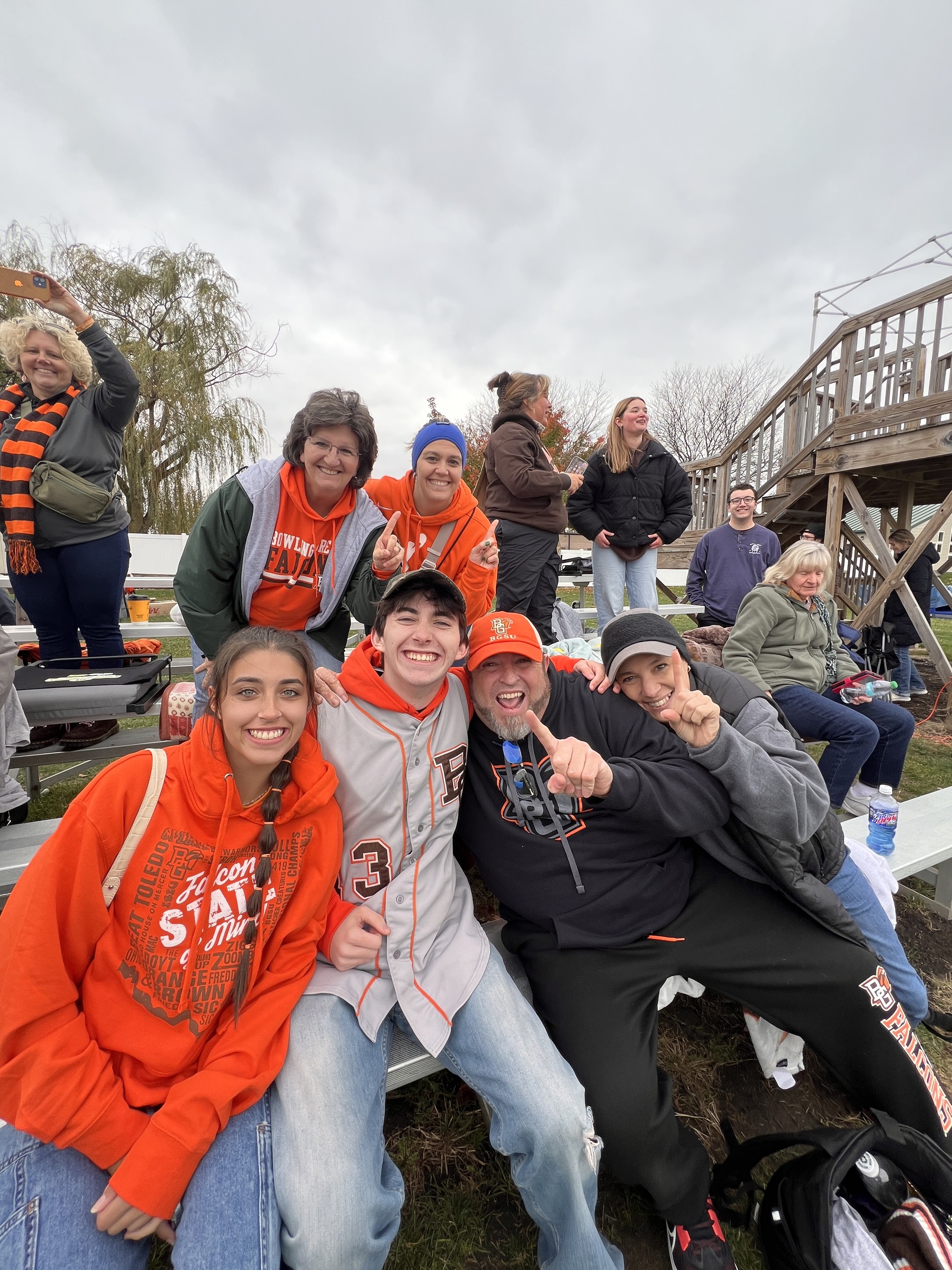 Spectators watch the rugby match from the bleachers.