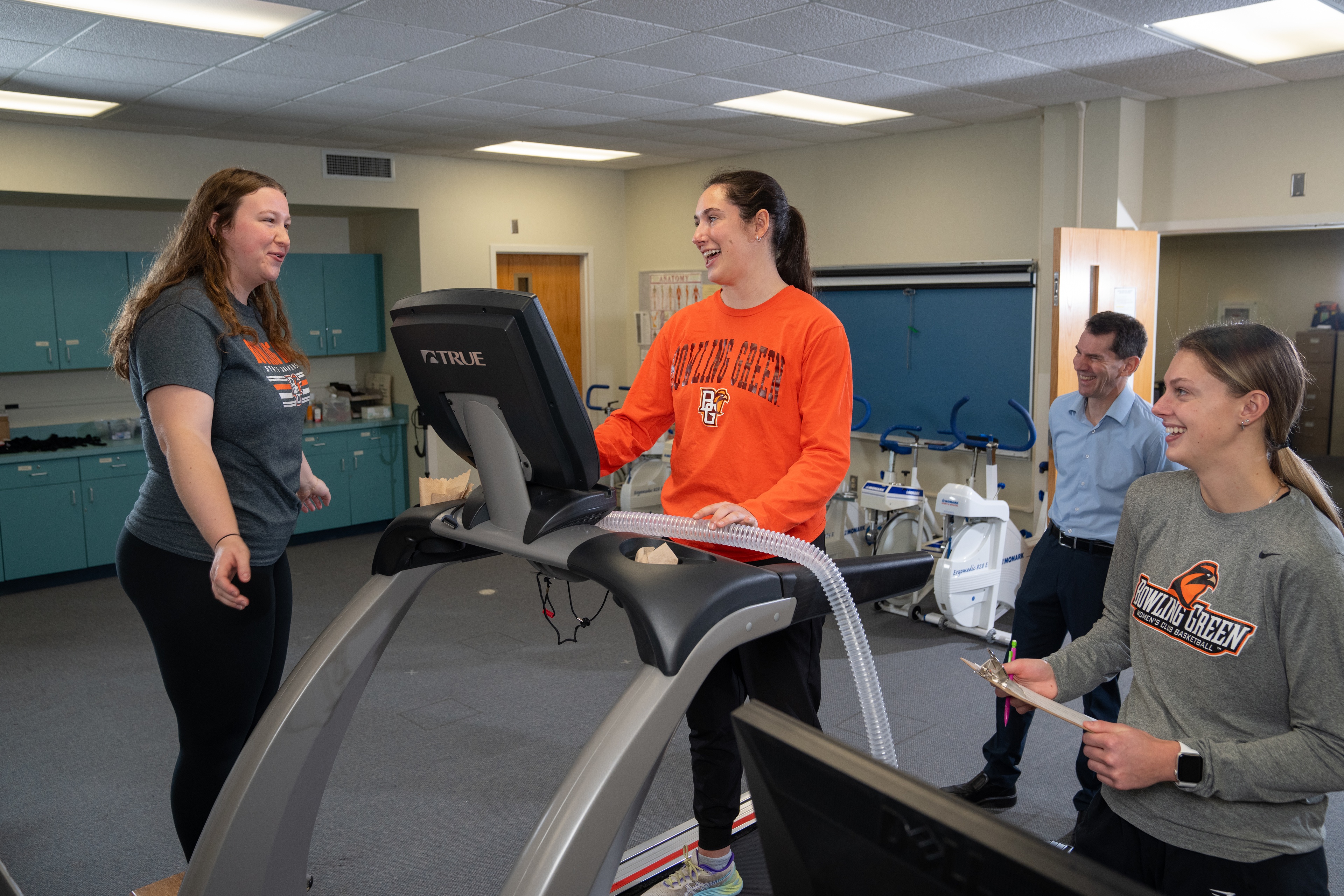 People standing around a treadmill.