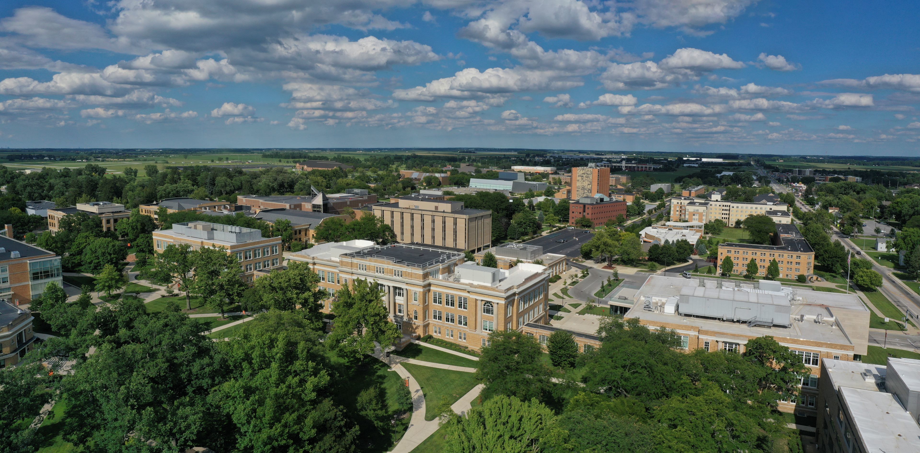 Drone picture of a brick building with trees and plants in the foreground