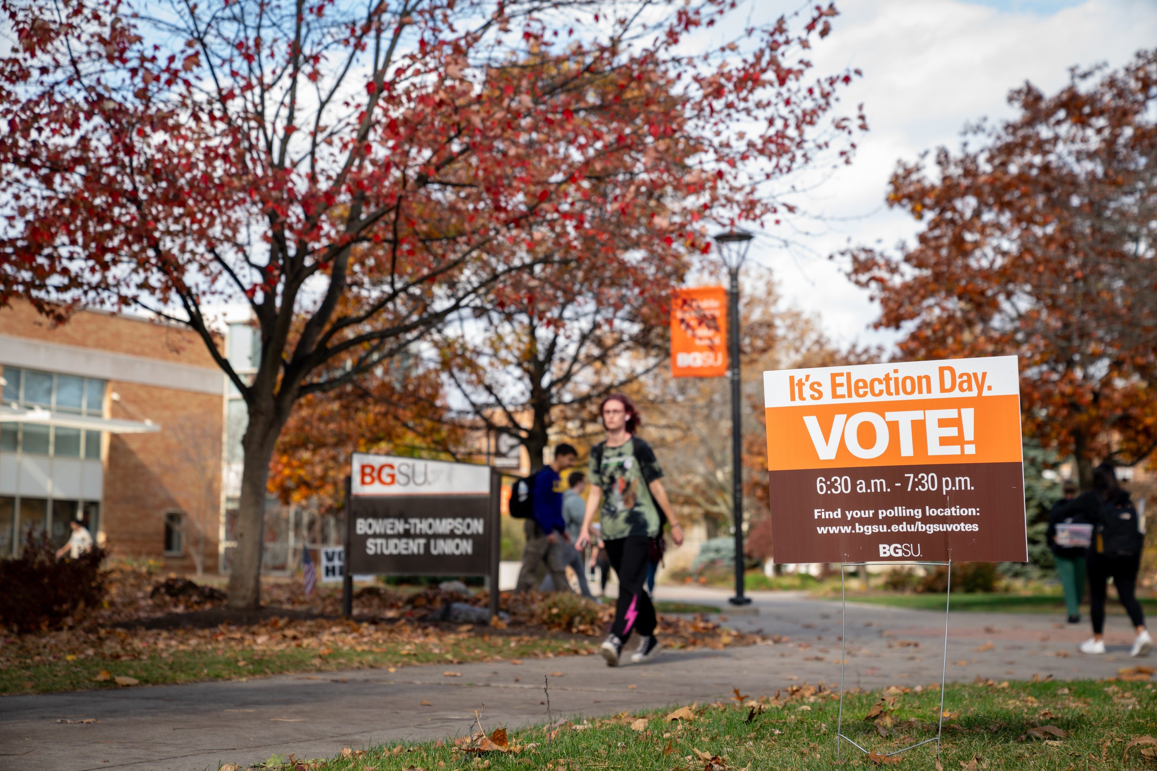 Students walk by sign that says "It's election day."