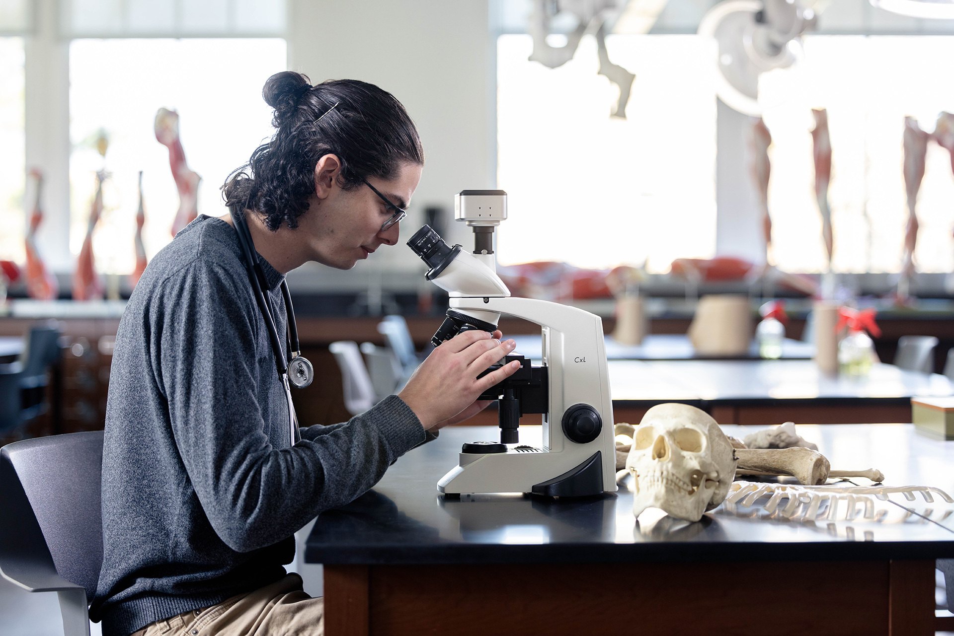 A student looks through a microscope