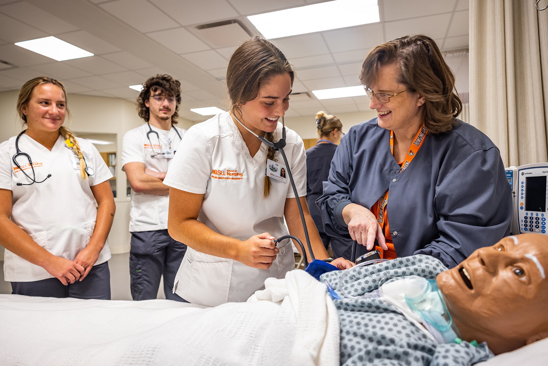 A nurse instructs students.