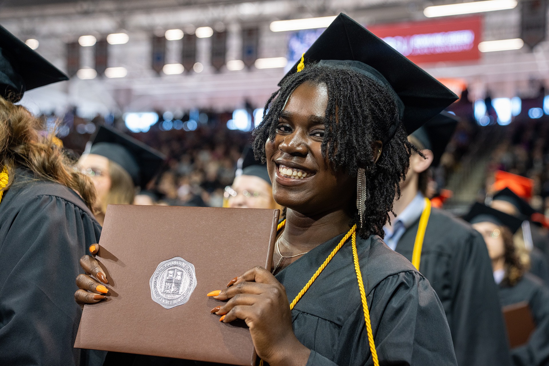 A BGSU graduate holds her diploma.