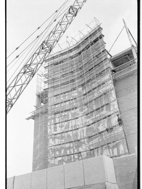 Black and white photo of construction of a building-size mural