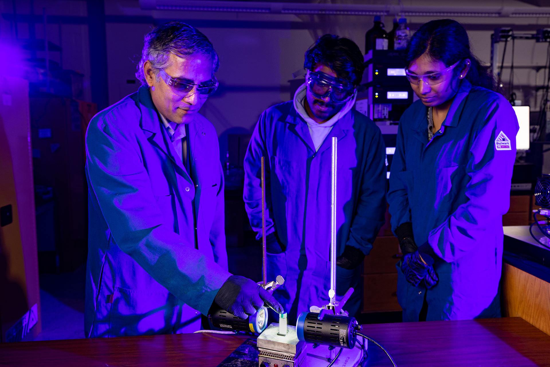 Students working with a professor in a lab