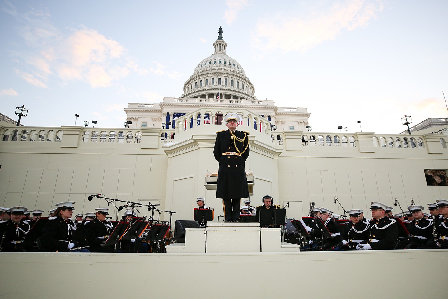 A band director stands in front of the U.S. Capitol.