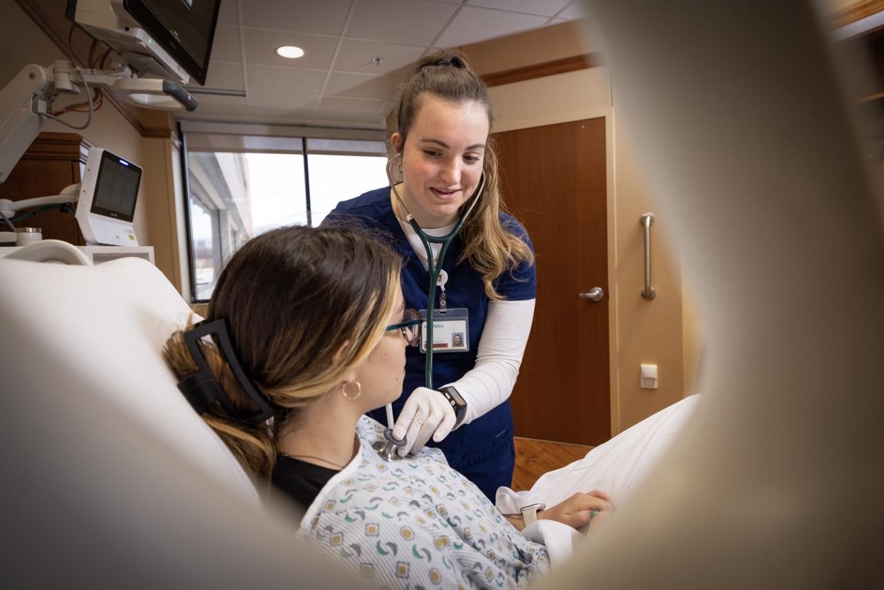 A nurse examines a patient.