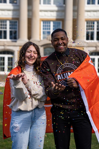 Two student throwing confetti