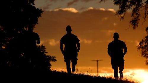 Three individuals running during sunsrise