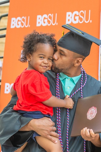 An indidual with baby at Commencement 