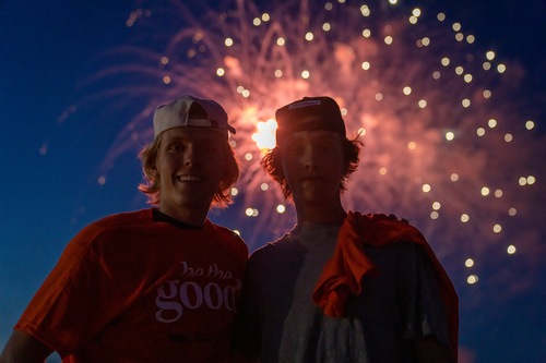 Two students with fireworks in background