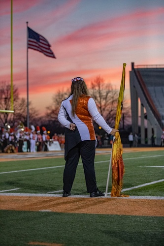 A student holding flag during sunset